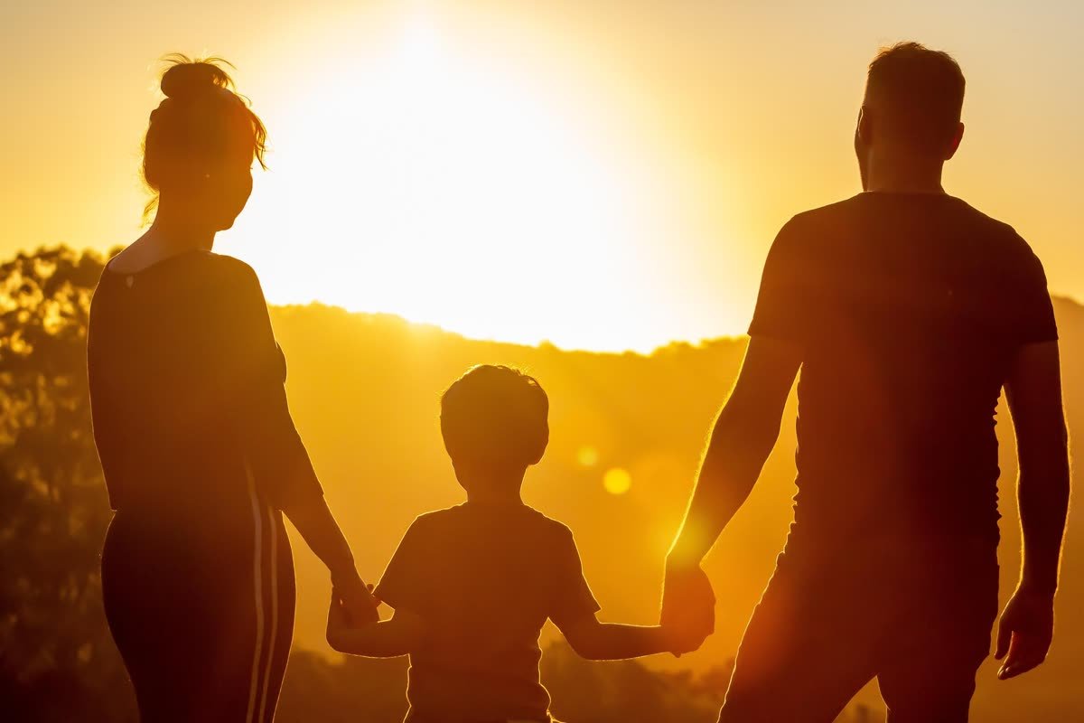 Famille réunie main dans la main au coucher du soleil